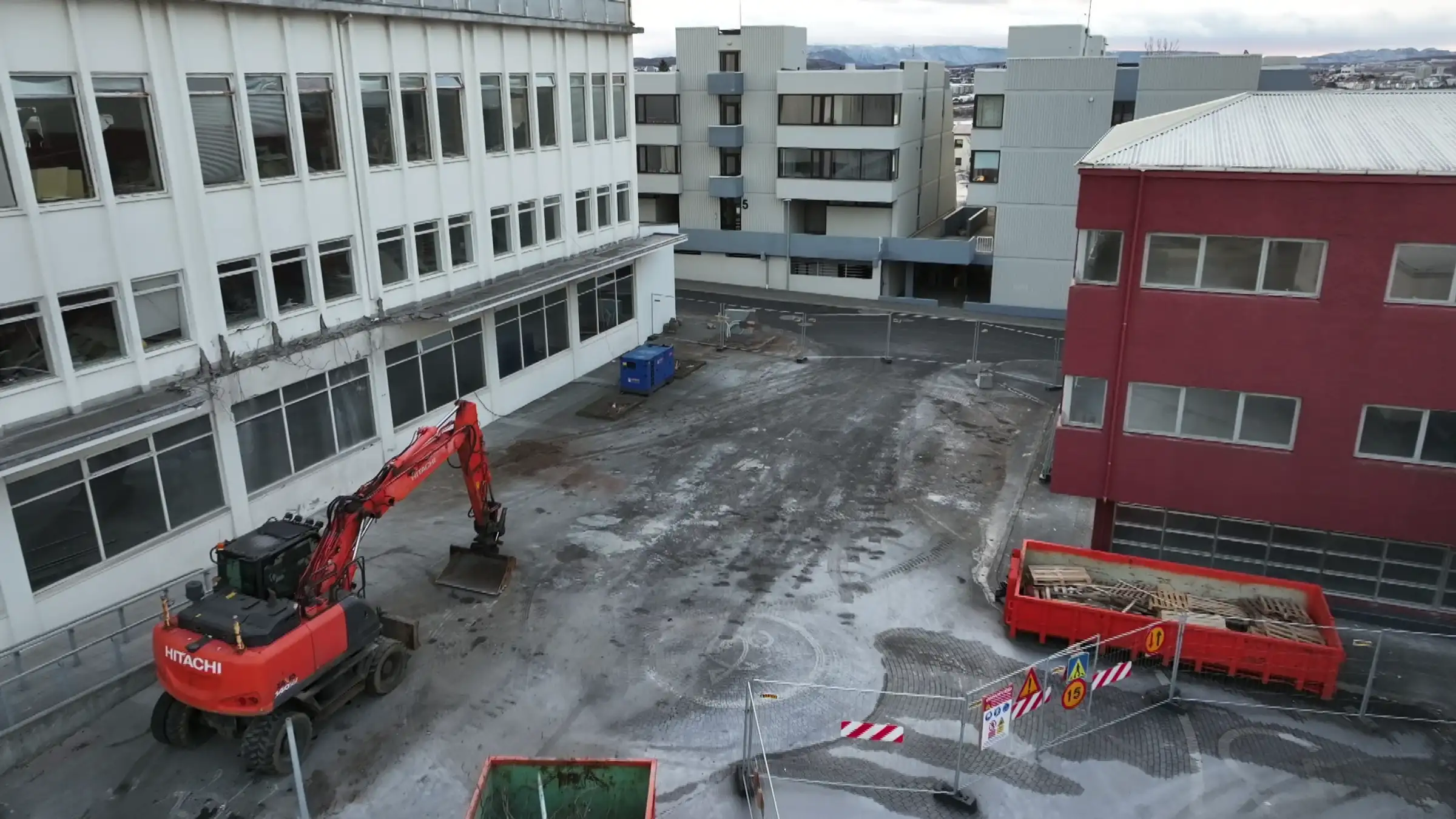 Myndin sýnir til vinstri Fannborg 2 þar sem búið er að rífa part úr þakskyggni byggingarinnar. Á myndinni eru girðingar sem afmarka svæðið og innan þeirra er rauð grafa sem stendur við Fannborg 2 Myndin sýnir til vinstri Fannborg 2 þar sem búið er að rífa part úr þakskyggni byggingarinnar. Á myndinni eru girðingar sem afmarka svæðið og innan þeirra er rauð grafa sem stendur við Fannborg 2